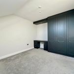 Spacious room with black wardrobe and desk.