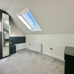 Bright attic room with skylight and wardrobe