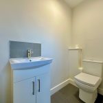 Minimalist bathroom with sink and toilet.