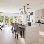 Modern kitchen with island and large garden view.