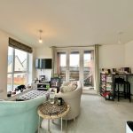 Cosy living room with books and guitar.