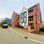Modern brick apartments with parked car.