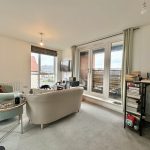 Cosy living room with large windows and bookshelves.