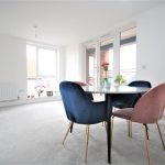Modern dining area with large windows and table.