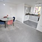 Modern kitchen with dining table and chairs.