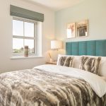 Cosy bedroom with fur duvet and teal headboard.