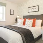 Modern bedroom with stylish decor and bright cushions.