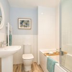 Modern bathroom with white fixtures and blue accents.