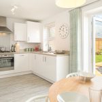 Modern kitchen with dining table and garden view.