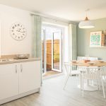 Modern kitchen with dining table and open doors.