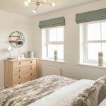 Modern bedroom with en-suite and wooden furnishings.