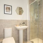 Modern bathroom with tiled shower and sink.