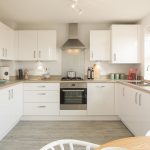 Modern white kitchen with appliances and countertops.