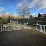 Fenced garden with decking and trampoline