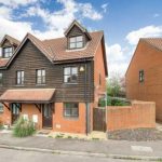 Modern semi-detached house with brick and wooden facade.