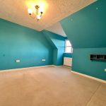 Empty blue room with carpet and ceiling light.