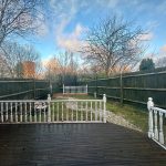 Fenced garden with trees and cloudy sky