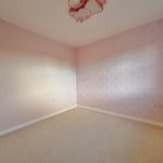 Empty pink room with patterned wallpaper.