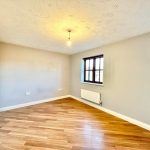 Empty room with wooden floor and white walls.