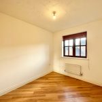 Empty room with wooden floor and window.