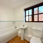 Modern bathroom with bathtub, sink, and window