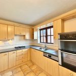 Modern kitchen with wooden cabinets and double oven.