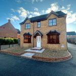 Brick house with driveway on sunny day.