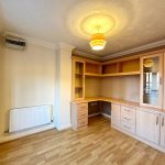 Empty room with wooden shelving and light fixture