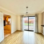 Bright dining room with garden view and wooden floor.