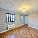 Empty room with wooden floor and bright window