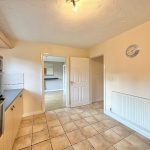 Spacious kitchen with tiled floor and oven.