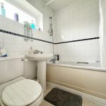 Modern bathroom with bathtub, toilet, and sink.