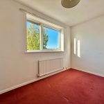 Empty room with red carpet and window view.