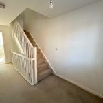 Bright hallway with stairs and carpet