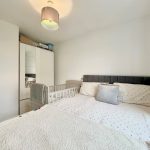 Modern bedroom with cot and mirrored wardrobe