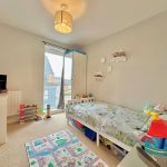 Children's bedroom with toys and decorative bedding.