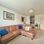 Cosy living room with tan sofa and artwork.