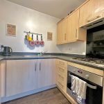 Modern kitchen with wooden cabinets and gas hob.