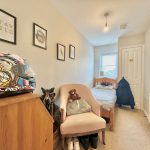 Small bedroom with bed and helmet on furniture.