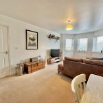 Spacious living room with large windows and sofa.