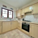 Modern kitchen with wooden cabinets and appliances.