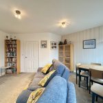 Cosy living room with sofa and dining table.