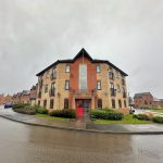Red-brick apartment building on a rainy day.
