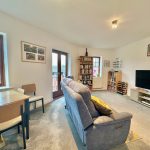 Spacious living room with bookshelves and TV.