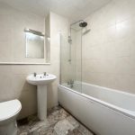 Modern bathroom with bath, sink, and toilet.