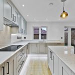 Modern kitchen with island and white cabinets.