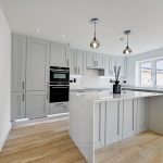 Modern kitchen with grey cabinets and wooden flooring