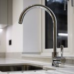 Modern chrome kitchen tap next to sink