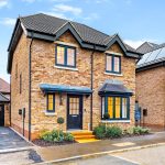 Newly built brick house with driveway.