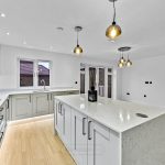 Modern kitchen with island and stylish pendant lights.